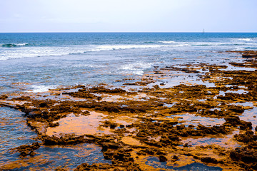 View of the Atlantic coast in Tenerife. Beach, volcanic stones, pebbles.