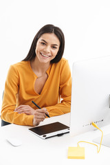 Portrait of caucasian young designer woman using graphic tablet computer and stylus pen in bright...