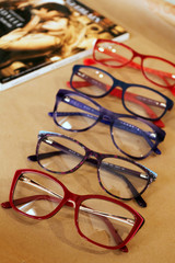 Set of glasses, optics store, flat lay with glasses, coffee, magazine.