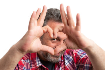 Fototapeta premium Closeup of man looking through heart shape