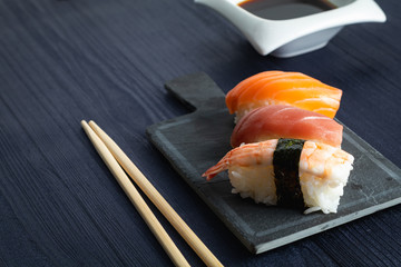 Elegant sushi on wood table. Some Nigiri, with soy sauce and chopstick