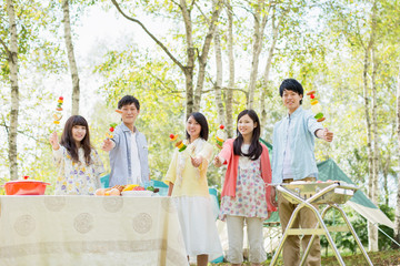  BBQの串を持ち微笑む大学生