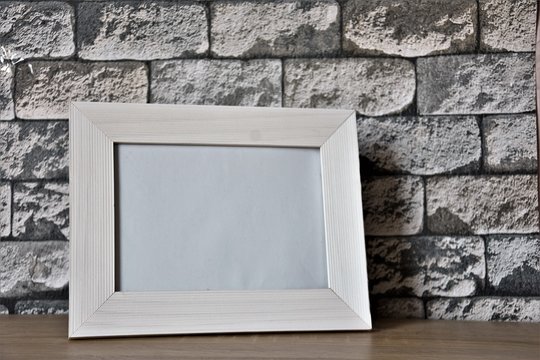 white wooden frame on gray brick wallpaper background