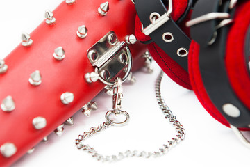 Obraz premium Sex toys for bdsm. Leather handcuffs and clamps for hands with thorns. Isolated handcuffs with chain on white background