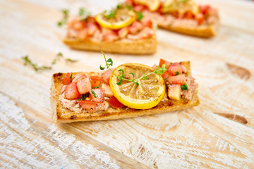Appetizer bruschetta with tuna and tomatoes. Italian cuisine.