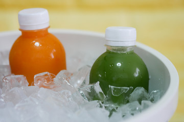the bottles of cold pressed fruit and vegetables juice in the ice bucket.