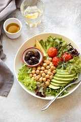Detox salad with chick pea, avocado, grilled tomatoes and olives. Healthy salad bowl for super food, clean eating, plant based diet concepts.