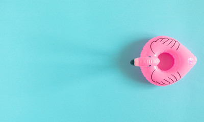 Summer beach composition. Inflatable mini flamingo on pastel blue background, pool float party,...