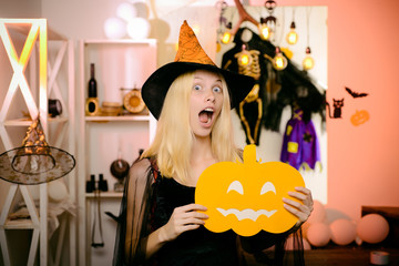 Surprised woman in witches hat and short dress. Vampire Halloween Woman portrait. Beautiful young...