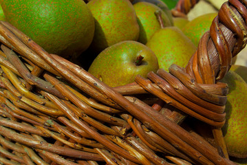 Torn green pears in a wicker basket.