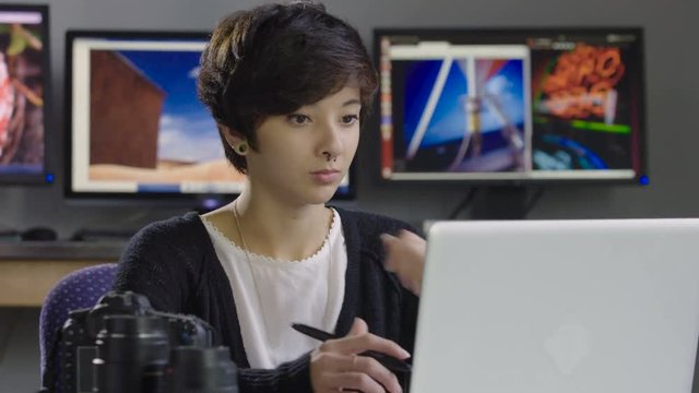Young, hip female using photoshop on computer, wide shot
