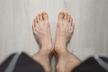 POV, man barefoot on the floor, male legs