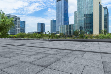 empty pavement and modern buildings in city.