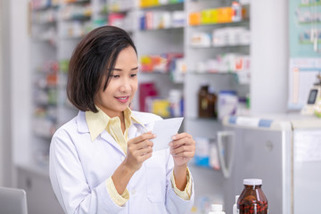 female pharmacist reading drug list on the paper