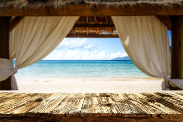 Wooden desk of free space and summer background of beach with sea and wooden window. Summer time 