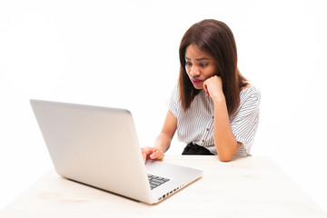 dark-skinned young girl typing on the laptop isolated on background