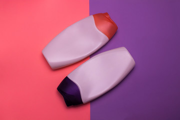 Beauty, decorative cosmetics bottles. Pink and purple colors background, flat lay, top view,...
