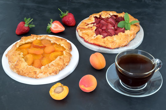 Strawberry and apricot galetta made from seasonal berries and fruits a cup of coffee.