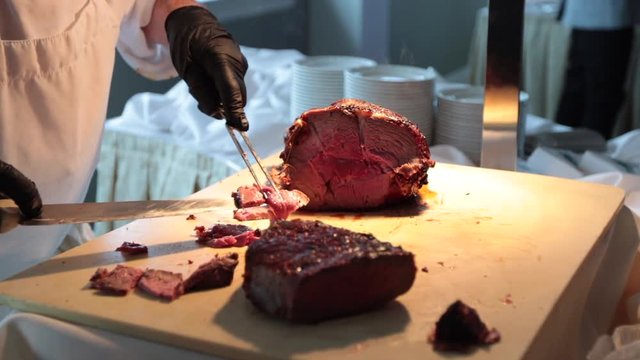 Carving pieces of steak on carving station slow motion