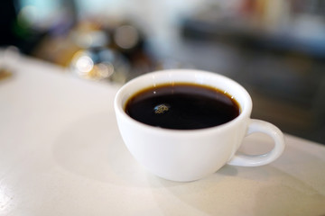 A cup of black coffee on table and blurred background, Perfect for breakfast time.