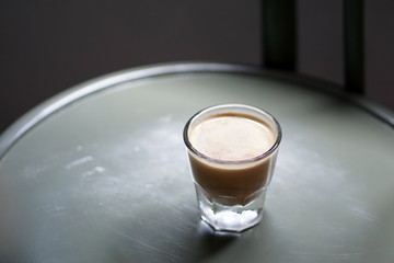 Dirty Coffee - A glass of espresso shot mixed with cold fresh milk on wooden table and blurred background, Perfect for breakfast time.