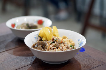 A bowl of dried noodle with fried wonton also known as spicy tom yum on table background and copy space, Traditional Thai food recipe, Popular street food of Thailand.