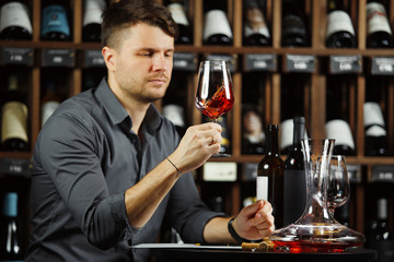 Sommelier looking at red wine glass with beverage