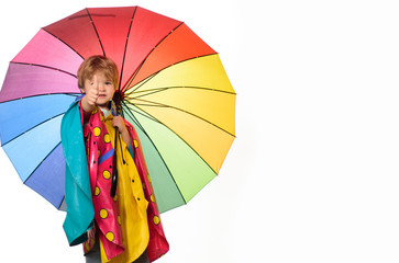 Little boy with rainbow-colored umbrella isolated on white background. Raining kids. Autumn mood and the weather are warm and sunny and rain is possible. Cloud rain umbrella. Raining concept.