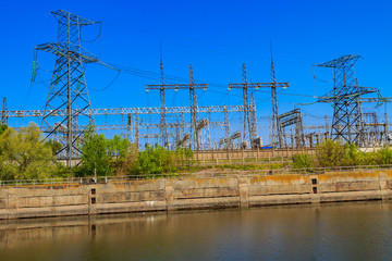 High voltage power lines towers on a riverbank