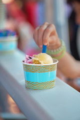 Buyer extends his hand for a cup of ice cream. Concept sale, street trading, food photography