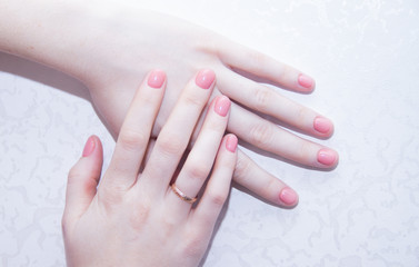 Naklejka premium Pink solid color manicure on female hands. Gentle manicure. Gel polish. Well-groomed nails.