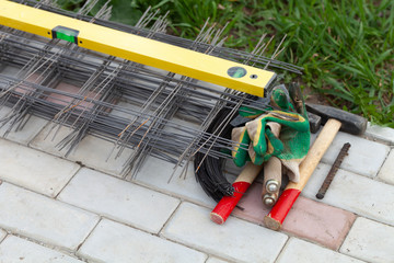 Metal mesh and working tools on the cement tiles. Selection focus. Shallow depth of field