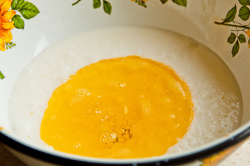 oil poured into milk in a metal bowl. dough preparation stage. recipe puff pastry. baking ingredients closeup top view