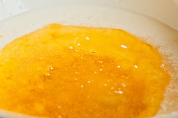 oil poured into milk in a metal bowl. dough preparation stage. recipe puff pastry. baking ingredients closeup top view