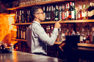 Man standing near bar stand and ordering alcohol for restaurant