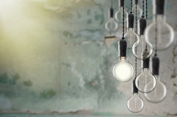 Fototapeta na wymiar Idea and leadership concept Vintage bulbs on wall background