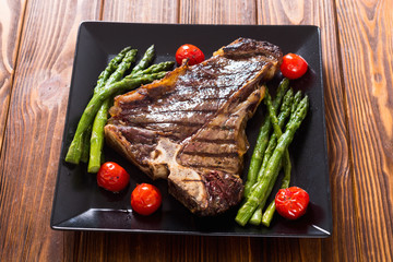Grilled T-bone steak with asparagus and cherry tomatoes