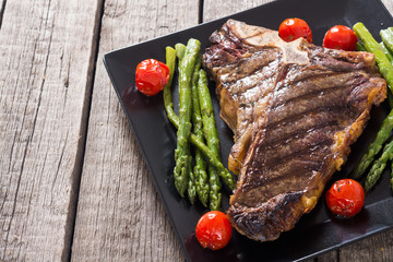 Grilled T-bone steak with asparagus and cherry tomatoes