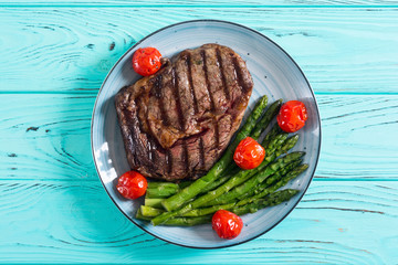 Grilled beef steak ribeye with cherry tomatoes and asparagus