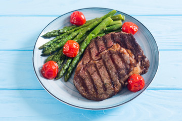 Grilled beef steak ribeye with cherry tomatoes and asparagus
