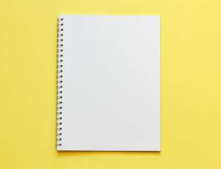 Top view, empty notebook on a yellow background