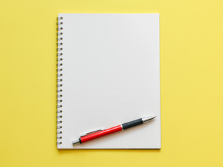 Top view, empty notebook on a yellow background