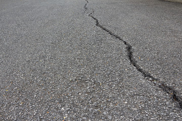 Fototapeta na wymiar There is a long crack in the tar road.