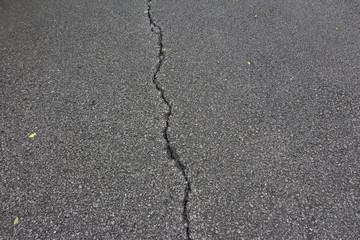 Fototapeta na wymiar There is a long crack in the tar road.