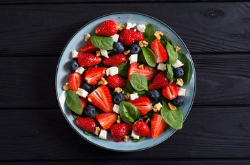 Summer Strawberry salad with spinach , cheese , nuts and blueberry