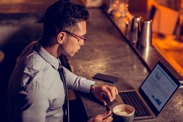 Freelancer working on laptop and drinking coffee