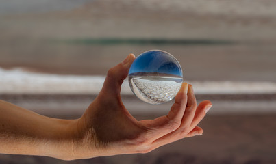 Hand holding glass ball at salt lakes in Atacama