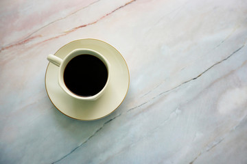 Cup of coffee on a marble textured background.