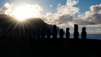 Bright star sun rising behind Moai silhouettes in Easter Island