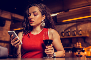 Dark-haired pretty woman reading message from boyfriend